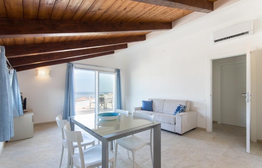 Attico a Castelsardo dopo l'home staging, mansarda arredata con toni caldi e vista mare
